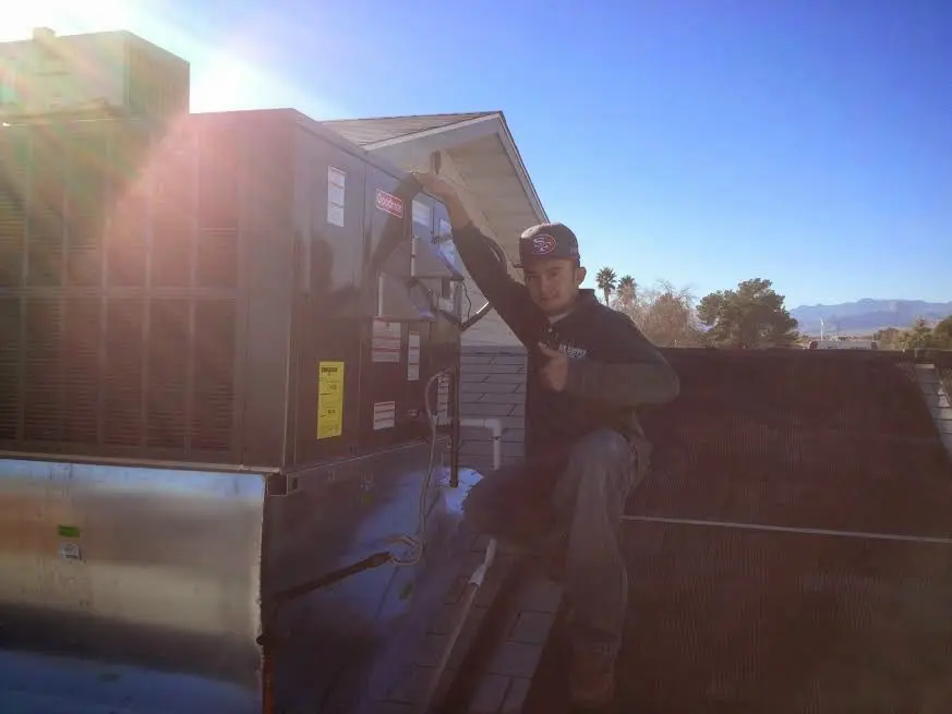 HVAC technician performing AC Tune-Up on a rooftop unit in Manassas Park